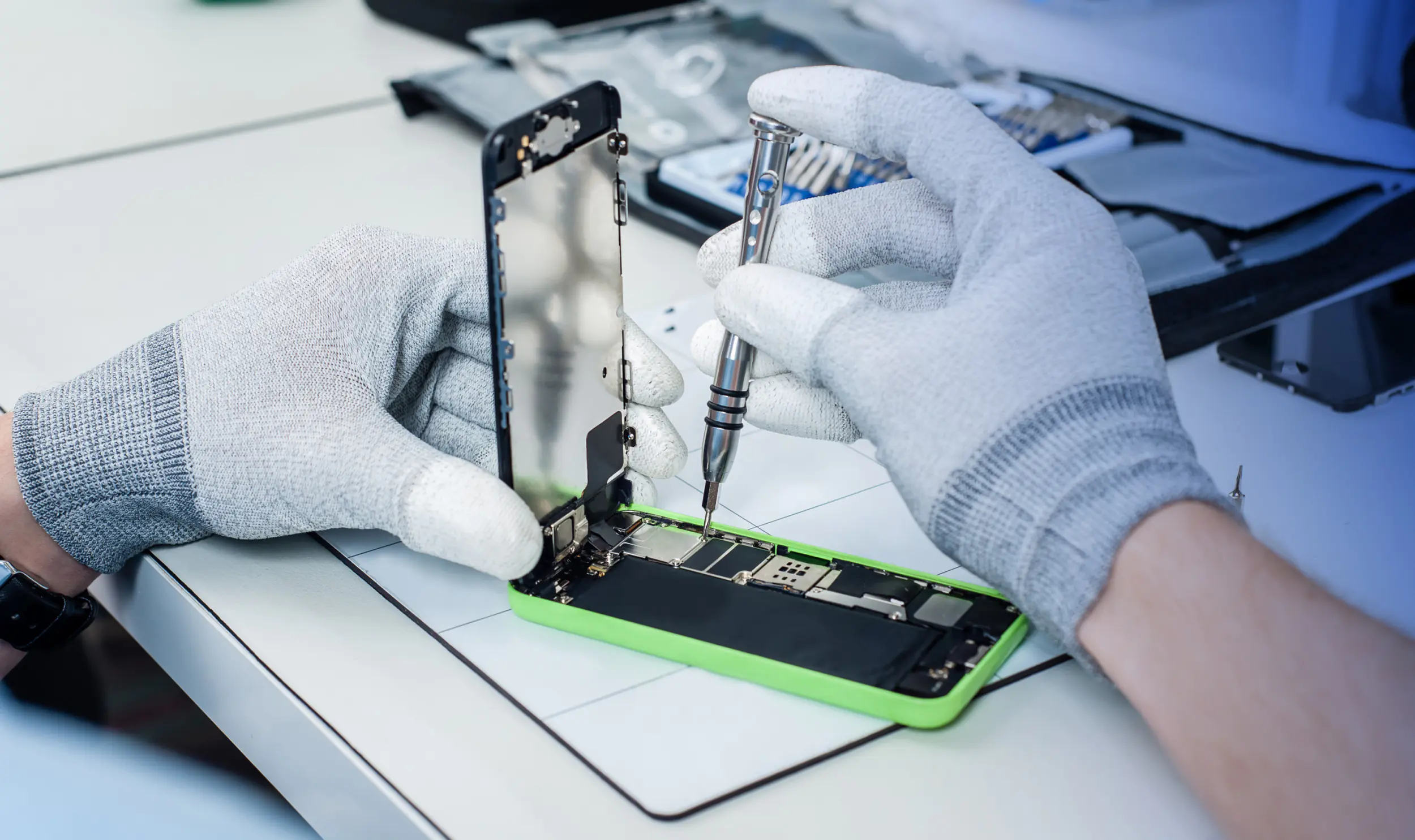 Mann repariert ein Smartphone 
